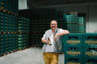 Steffen Marx steht in einer Brauerei vor Bierkästen in der Brauerei von Giesinger.