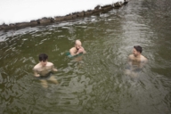 Drei Männer beim Eisbaden im Winter im Eisbach