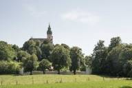 In front of Andechs Monastery there is a long wall and a fence.