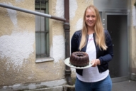 Die Gründerin von Kuchentratsch Katharina Mayer mit einem Kuchen in der Hand vor der Backstube in München