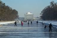 Schlittschuh-Läufer auf dem gefrorenen Kanal des Schloss Nymphenburg in München.