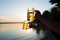 Leute trinken beim Sonnenuntergang Bier am Ammersee im Umland von München.