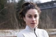 Portrait der Profi-Trailrunnerin Kimi Schreiber in Sportkleidung an der Isar in München.