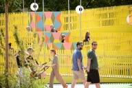 Several passers-by are strolling across the colourful grounds of FLUX next to the Pinakothek der Moderne