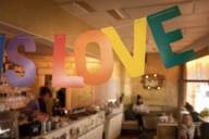 Eine bunte Girlande mit dem Schriftzug LOVE hängt in einem Café.