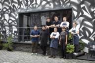 Das Team vom Mural Restaurant steht versammelt auf der Terrasse vor dem Lokal