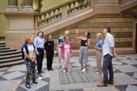 Eine Gästeführerin erklärt ihrer Gruppe die Dachkonstruktion in der zentralen Halle des Münchner Justizpalastes.