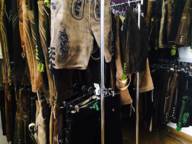 Viele verschiedene Lederhosen hängen auf Kleiderständern in einem Geschäft.