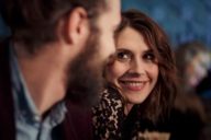 Una donna sorride a un uomo con la barba in un bar di Monaco di Baviera.
