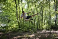 Junger Mann mit einer Aktion aus dem Taekwon-Do in einem Wald in München.