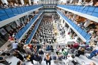 Vista dall'alto del foyer dell'HP8, dalla cui galleria moltissime persone guardano un'orchestra nell'atrio.