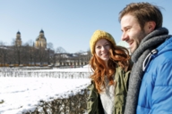 Ein Paar ist an einem sonnigen Wintertag im Hofgarten in München.