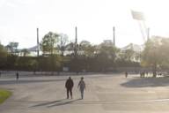 Zwei Menschen im Gespräch machen einen Spaziergang durch den Olympiapark.