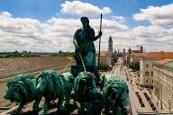 Lion-quadriga on top of the Siegestor with the skyline of the inner city of Munich