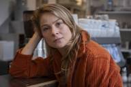 The author Lea Ruckpaul leans her forearm on a counter and looks into the camera.