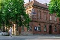 Ein Arbeiter in weißer Arbeitskleidung steht vor dem Gebäude des Wirtshauses im Schlachthof in München.