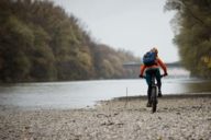 A woman is riding a mountain bike along the Isar River.