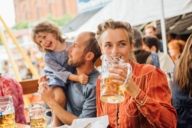 Eine Frau trinkt eine Mass Bier auf der Auer Dult in München