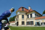 Ein Porzellan-Papagei im Garten der Porzellan-Manufaktur Nymphenburg in München.
