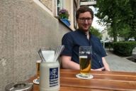 Mann mit Bier vor einem Gasthaus in München.
