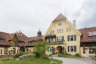 Außenansicht des Hotels Gut Sonnenhausen, ein altes, gelb gestrichenes Backsteinhaus mit Vorgarten.