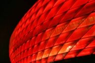 Die Allianz-Arena in München leuchtet rot im Abendlicht.