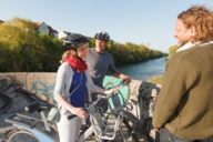 Un gruppo di ciclisti sta chiacchierando su un ponte sul fiume Isar a Monaco.