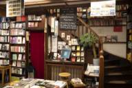 Blick in eine alte Buchhandlung in München mit Regalen, Holztreppe und Büchertisch