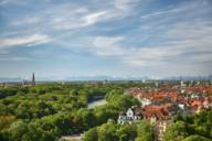 Ein Blick über das grüne München und die Isar bis zu den Bergen