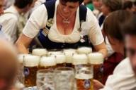 Eine Bedienung bringt Masskrüge an einen Tisch auf dem Oktoberfest in München.