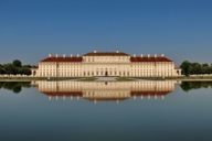 Das Schloss Schleissheim spiegelt sich im Wasser des Sees.