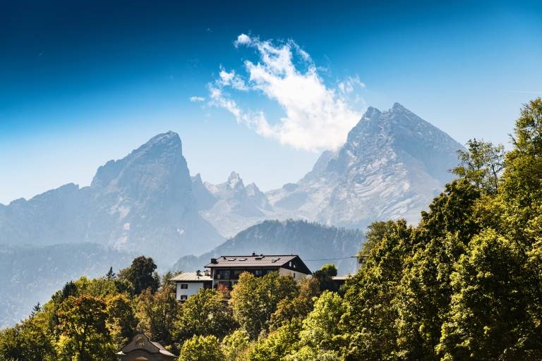 A house stands in the countryside in front of the Watzmann massif in Berchtesgadener Land