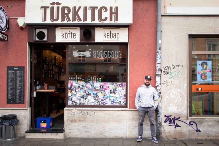 Sternekoch Florian Berger vom Restaurant Gabelspiel in München mit Cap steht vor dem türkischen Imbiss Türkitsch.
