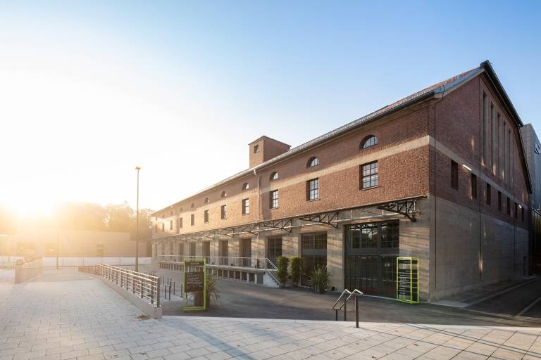 Außenansicht der Halle8, die zum HP8 Gasteig in Sendling gehört und von der Morgensonne angestrahlt wird.