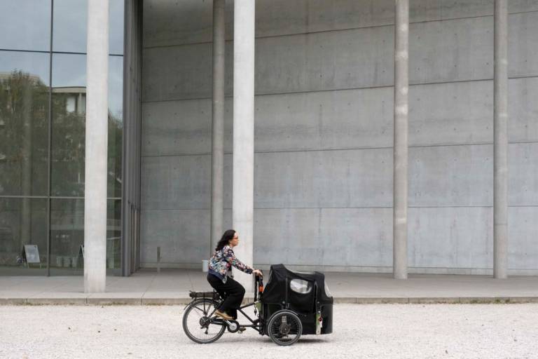 Laura Schieferle fährt auf ihrem Lastenfahrrad an der Pinakothek der Moderne vorbei.