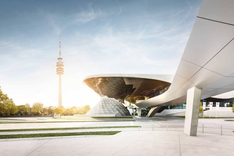 Die Doppelhelix der BMW Welt in Münchenmit dem Olympiaturm im Hintergrund.