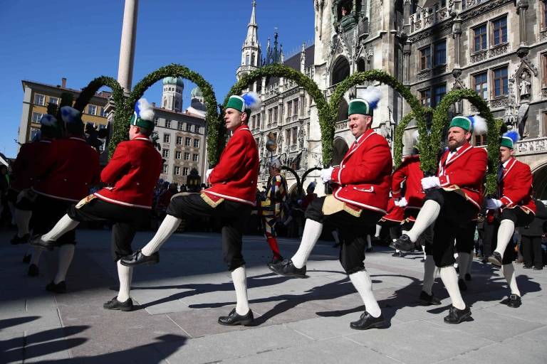 The Munich Schäffler in red jackets and black knee breeches dance the traditional Schäffler dance in front of the New Town Hall on Munich's Marienplat