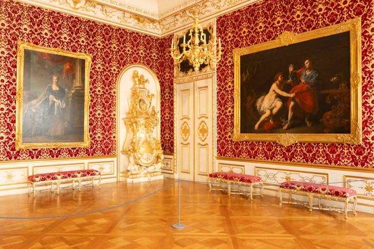 Ein rot-goldener Raum in der Residenz mit großen Gemälden und antiken Möbeln