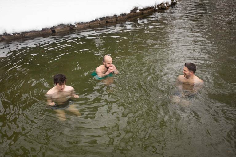 Drei Männer beim Eisbaden im Winter im Eisbach