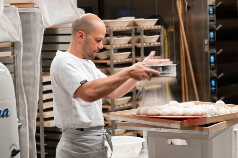 Ein Mann mit Glatze arbeitet in einer Backstube in München