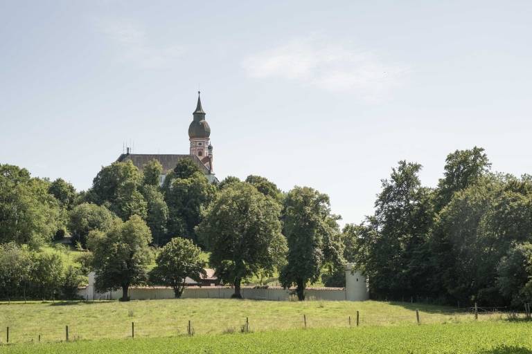 Vor dem Kloster Andechs steht eine lange Mauer sowie ein Zaun