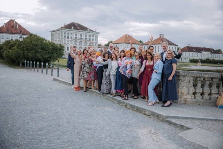 Absolvent*innen und Lehrkräfte des Gästeführerkurses 2025 posieren vor der Kulisse von Schloss Nymphenburg