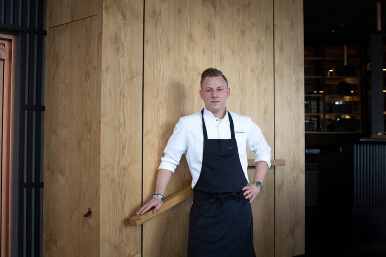 Michelin-starred chef Stefan Barnhusen stands with an apron in his restaurant