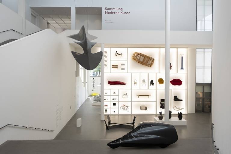 The large display case with exhibits in the entrance area of Die Neue Sammlung - The Design Museum in Munich.