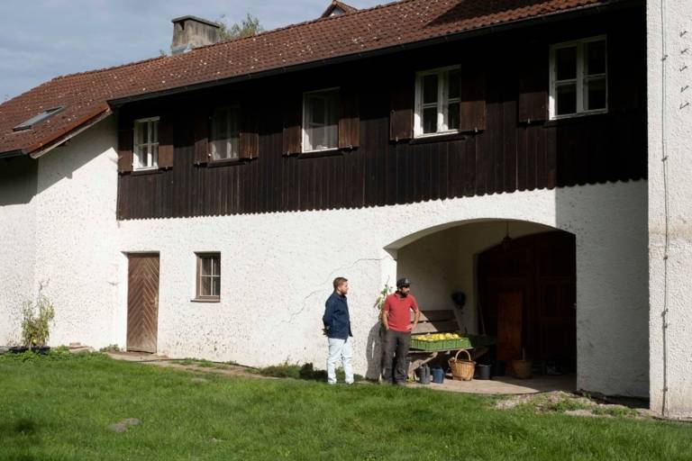 Wolfgang Hingerl and ‘Mogli ’ Billersberger stand in front of a gate at the farm.
