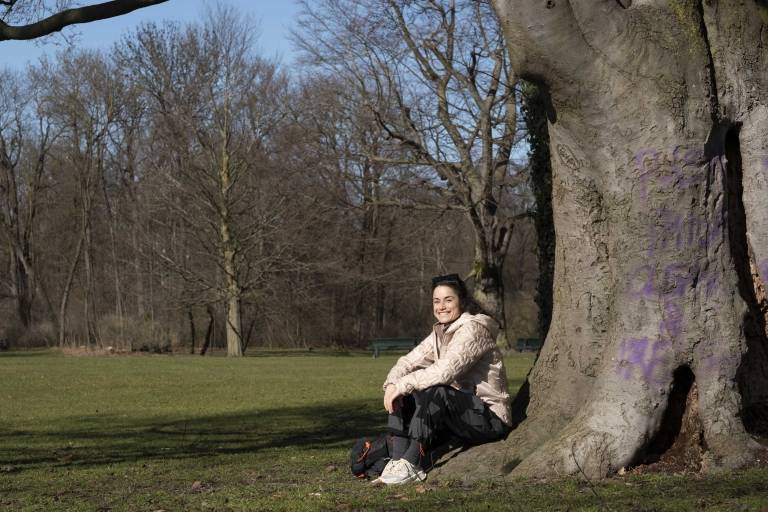 Foto von Kimi Schreiber an einem Baum in einem Park in München.