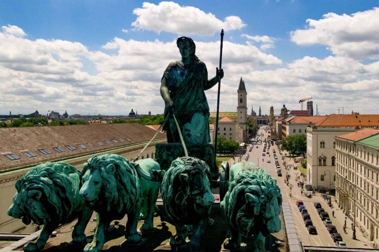 Lion-quadriga on top of the Siegestor with the skyline of the inner city of Munich