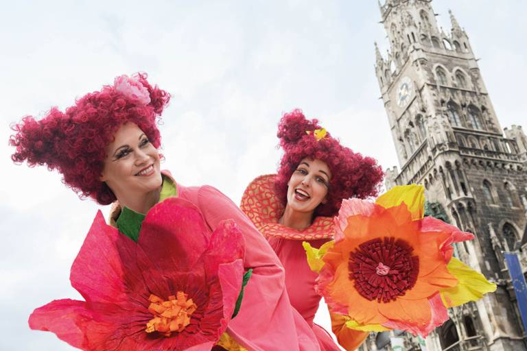Zwei Frauen in Blumenkostümen während des Stadtgeburtstages auf dem Münchner Marienplatz.