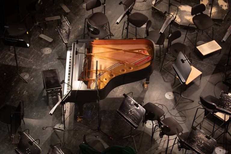 Blick in einen Orchestergraben mit einem großen Klavier in München.