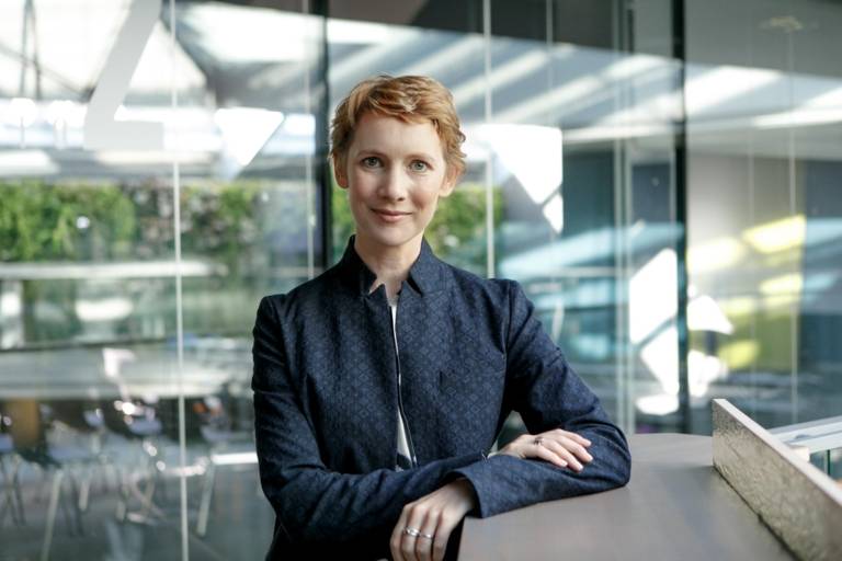 Eine Frau steht im Foyer eines Hotels in München und blickt in die Kamera.